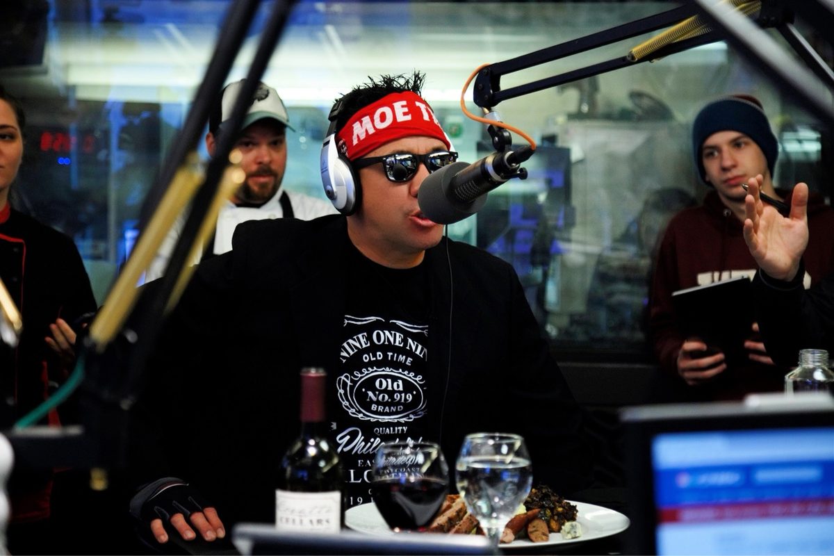 Moe in a radio studio with headphones on, speaking into a broadcast mic