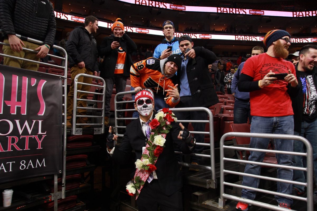 Moe in sugar skull paint and a flower lei pointing to the Wing Bowl crowd