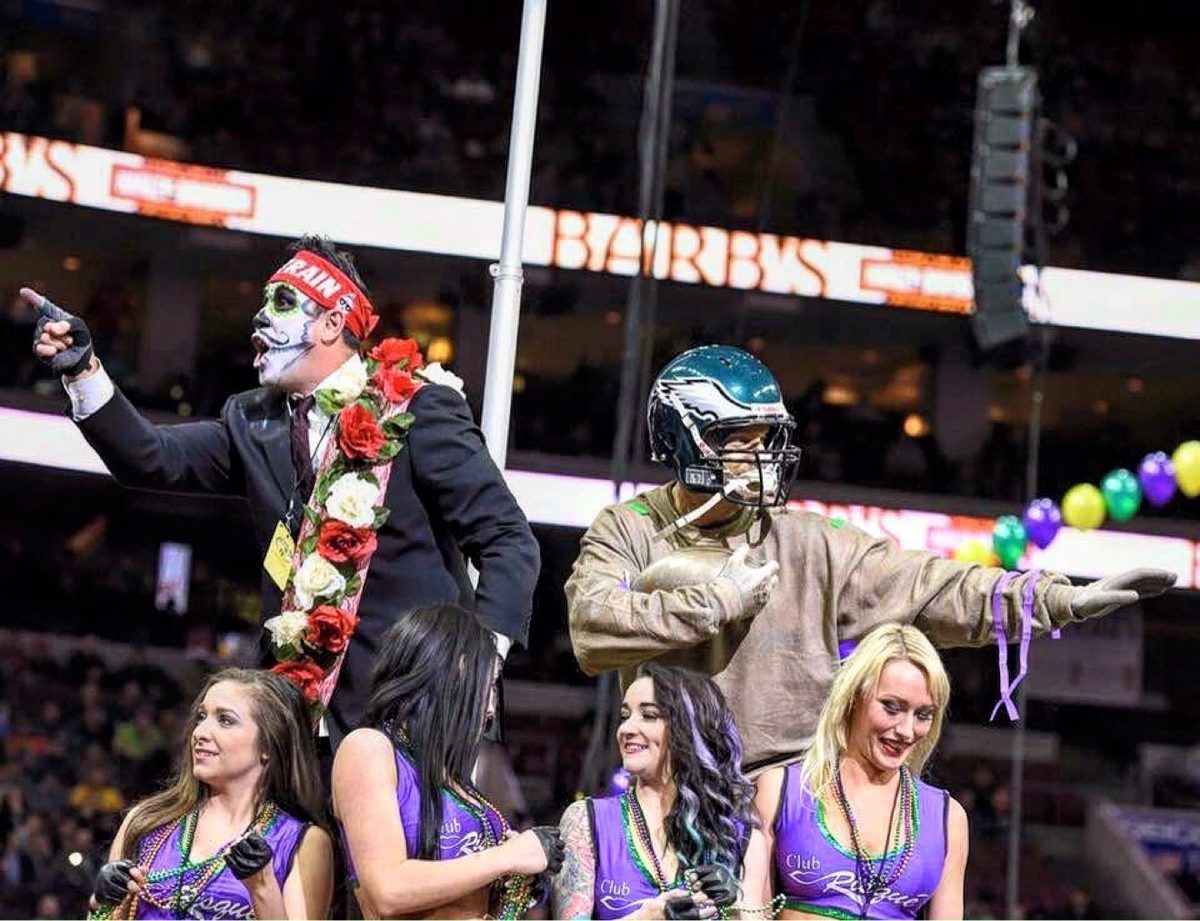 Moe in a suit and flower garland on the Wing Bowl stage with the Eagles mascot